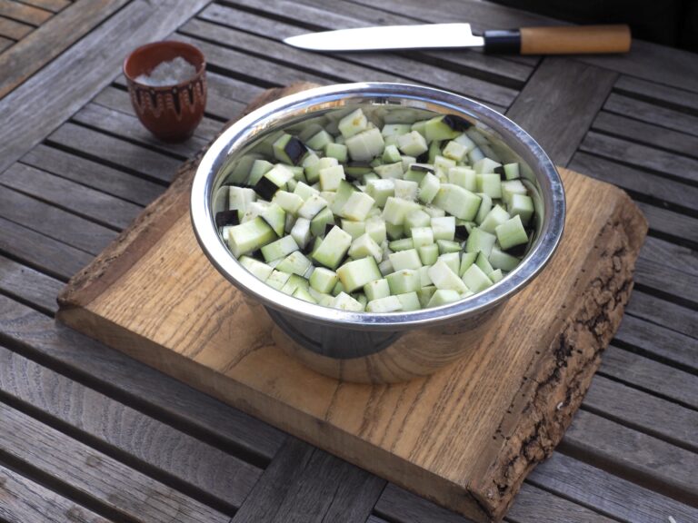 Mettre les carrés dans un saladier que vous remplissez d’eau froide que vous salez de 4 pincées. Bien remuer pour que les aubergines soient immergées. Le liquide salé va assaisonner l’aubergine et l’attendrir. On appelle cela une saumure.
